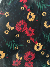 Load image into Gallery viewer, Blusa floral negra con estampado rojo y amarillo, corte off-shoulder, combinada con mahones cortos


